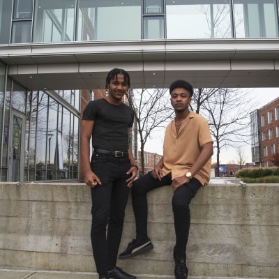 Alvaro and Angelo, international students from Mozambique, standing outside a Salem State University building